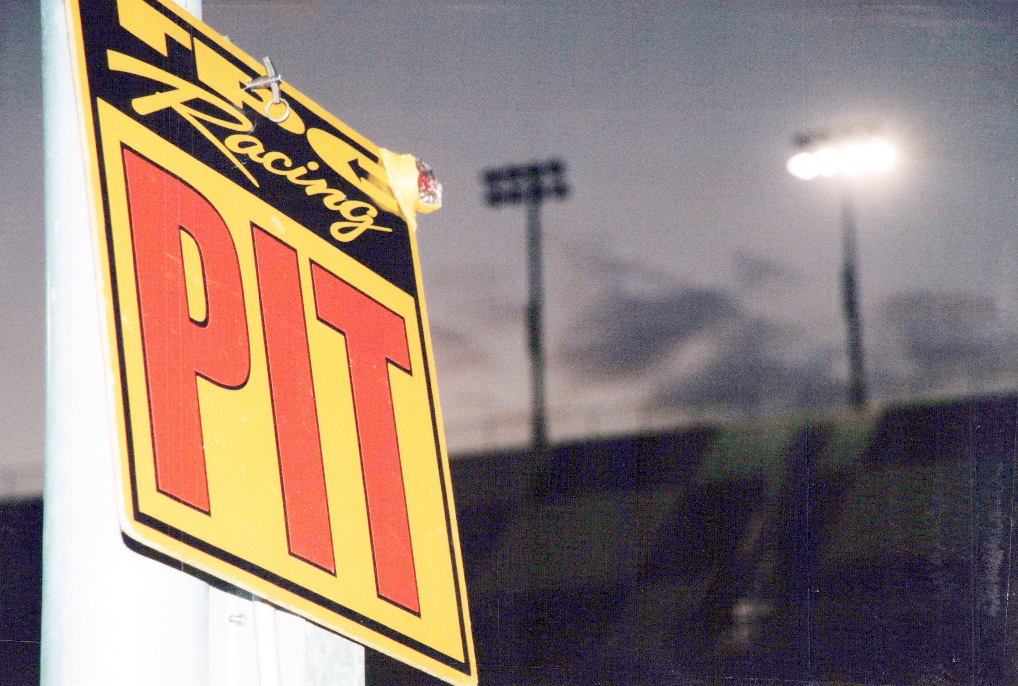 Close-up of a TPC Racing logo on a pit lane sign. 